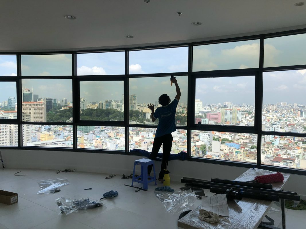 Kỹ thuật viên thi công dán phim cách nhiệt cửa kính
